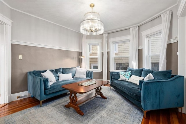 living room featuring a chandelier, crown molding, and hardwood / wood-style flooring