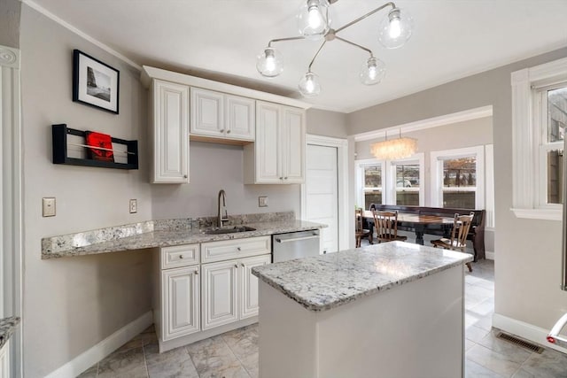 kitchen featuring pendant lighting, a wealth of natural light, a center island, sink, and stainless steel dishwasher