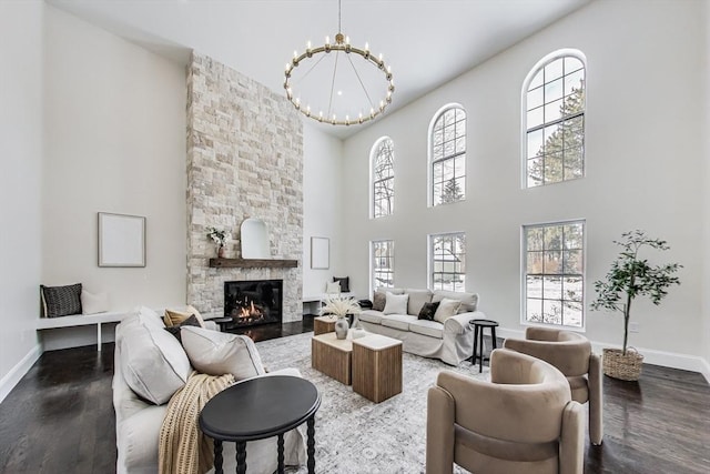 living room featuring a fireplace, baseboards, and wood finished floors