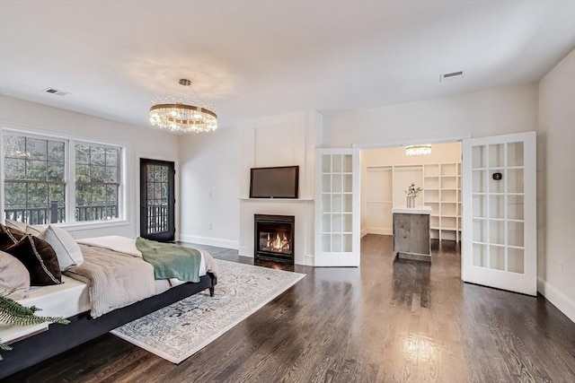 bedroom with a chandelier, dark wood-style flooring, visible vents, and baseboards