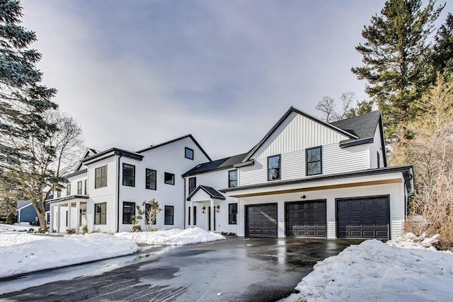 modern farmhouse style home with a garage, driveway, and board and batten siding