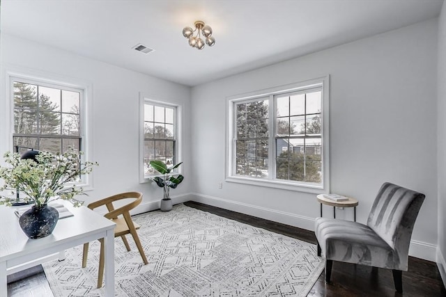 living area featuring wood finished floors, visible vents, and baseboards