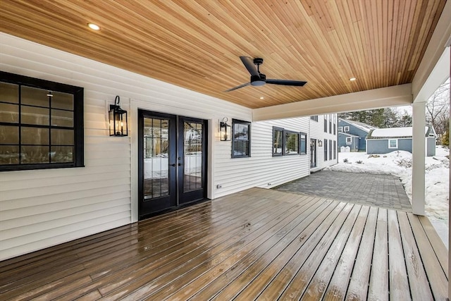 snow covered deck with a ceiling fan and french doors