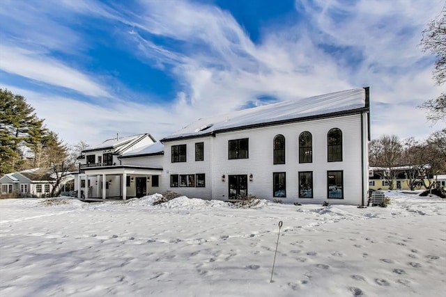 view of snow covered back of property