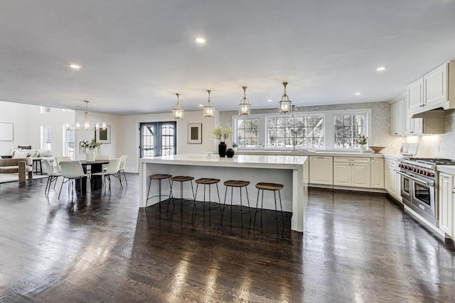 kitchen with white cabinets, a breakfast bar, range with two ovens, and open floor plan