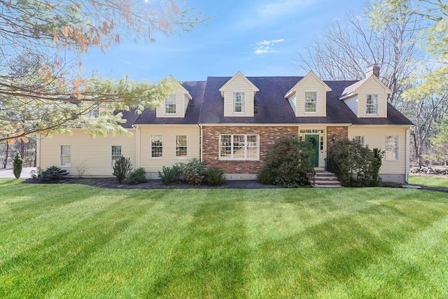 cape cod home with brick siding and a front yard