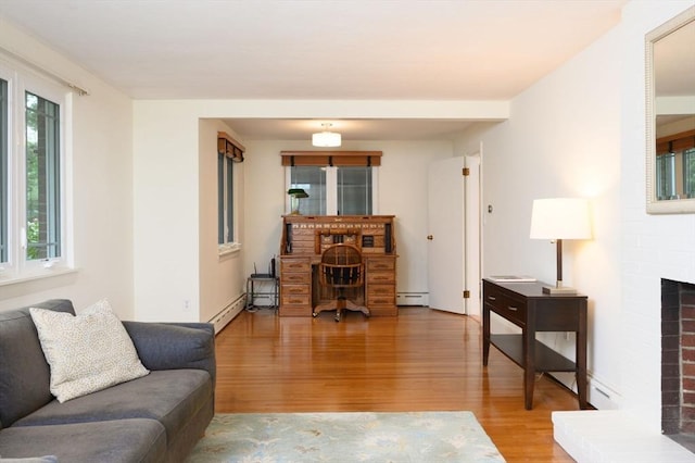13 Smith Rd, Hingham, MA 02043 - living area with a baseboard heating unit, light wood finished floors, and a brick fireplace