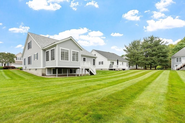 45 Augusta Way Unit 23, Chelmsford, MA 01863 - rear view of house featuring stairs, a wooden deck, a lawn, and a shingled roof