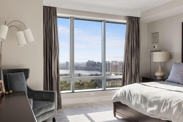 bedroom with carpet flooring, baseboards, ornamental molding, and a water view