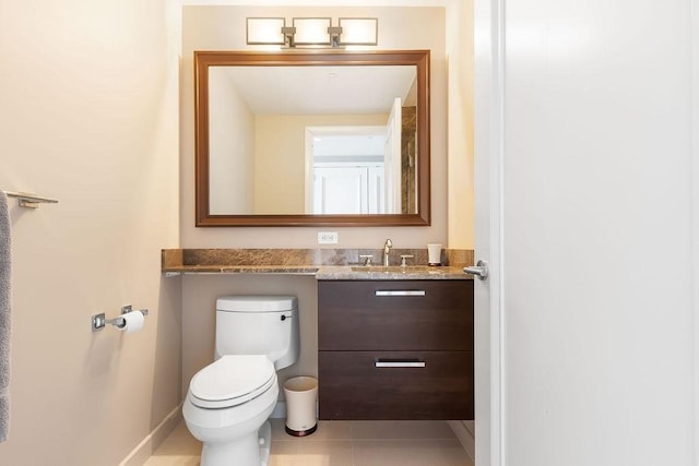 bathroom with vanity, toilet, tile patterned floors, and baseboards