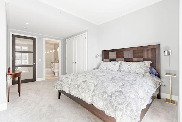 bedroom featuring crown molding, carpet floors, baseboards, and ensuite bathroom
