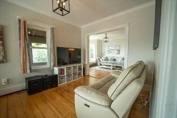 living room with wood finished floors and crown molding