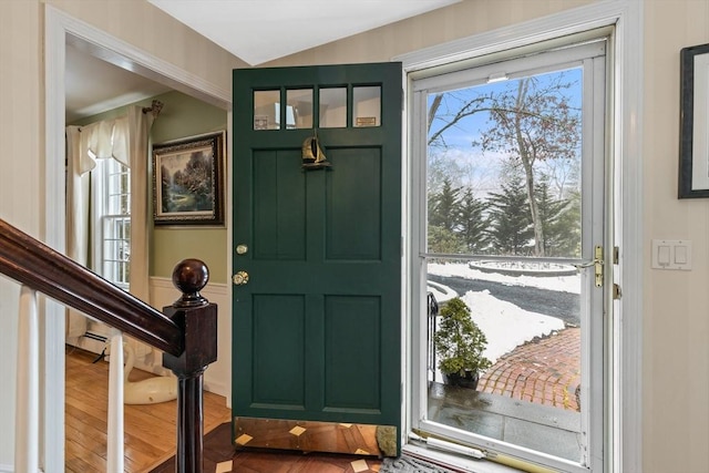 entryway featuring lofted ceiling, stairs, and wood finished floors