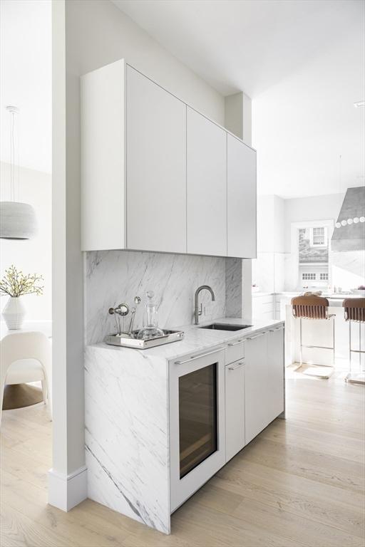 kitchen with sink, light wood-type flooring, and white cabinetry