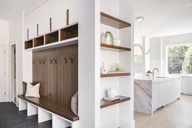 mudroom with sink and light hardwood / wood-style floors