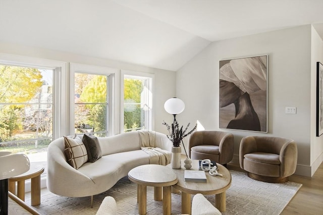 sitting room with hardwood / wood-style floors, a wealth of natural light, and vaulted ceiling