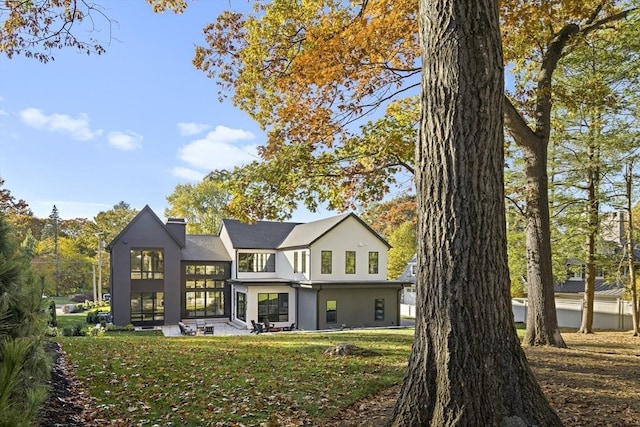 back of house with a patio area and a lawn