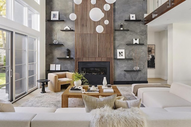 living room with a fireplace and a towering ceiling