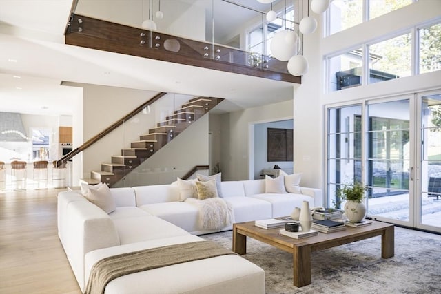 living room with a high ceiling and light hardwood / wood-style flooring