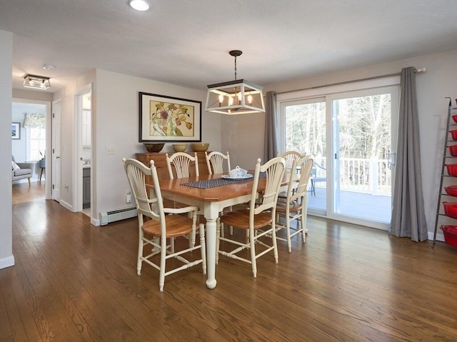 dining area featuring hardwood / wood-style floors, a healthy amount of sunlight, baseboards, and a baseboard radiator