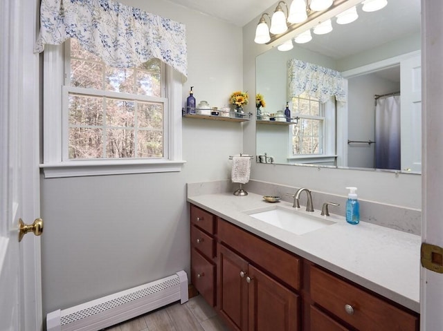 full bath with plenty of natural light, vanity, and a baseboard heating unit