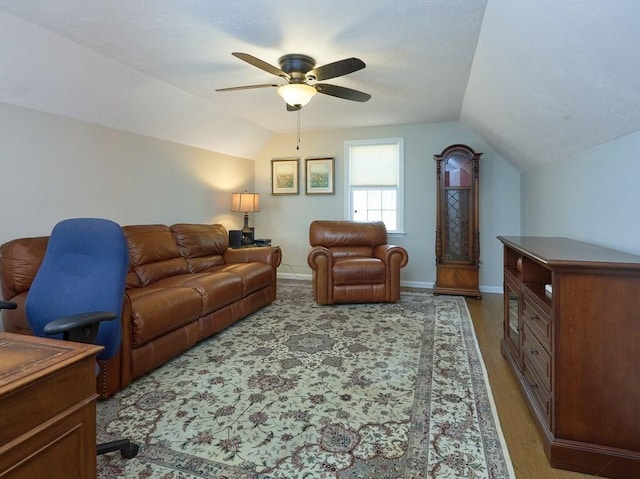 living room with baseboards, lofted ceiling, and ceiling fan