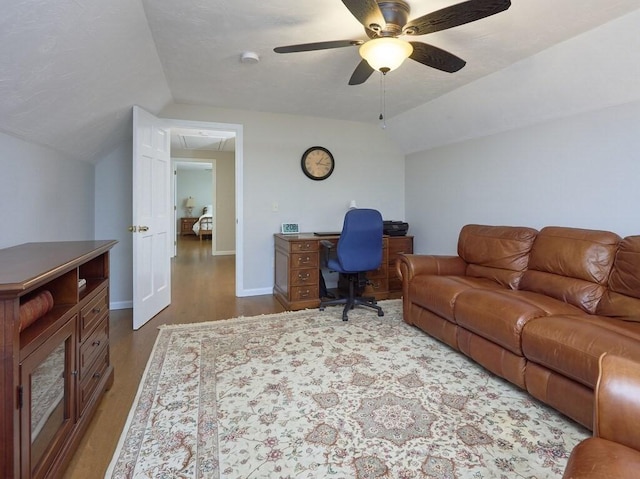 office space featuring baseboards, ceiling fan, dark wood finished floors, attic access, and lofted ceiling