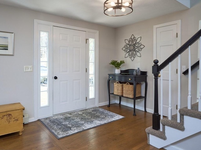 foyer entrance with stairs, plenty of natural light, and dark wood-style floors