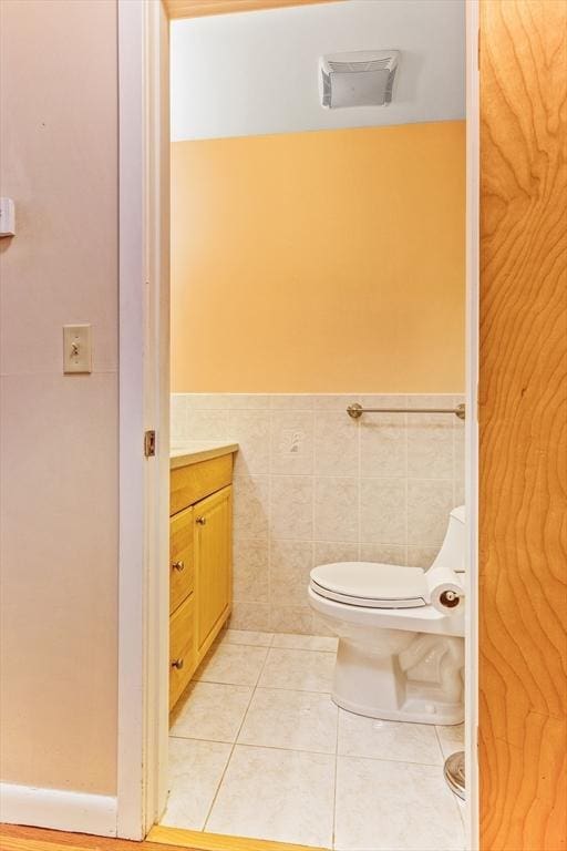 374 Great Rd Unit 10, Acton, MA 01720 - half bathroom with toilet, a wainscoted wall, tile patterned floors, vanity, and tile walls