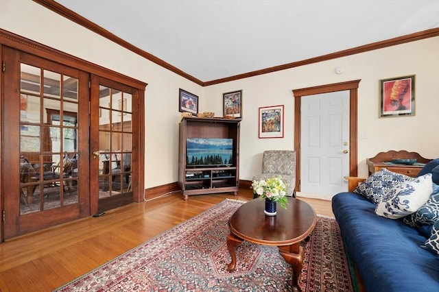 living room featuring wood finished floors, crown molding, french doors, and baseboards