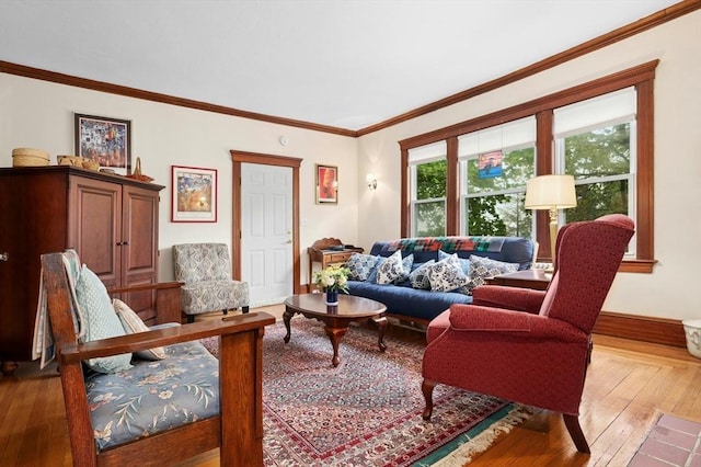 living area with hardwood / wood-style floors, baseboards, and crown molding