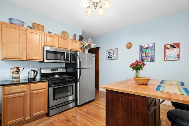 kitchen featuring stainless steel appliances, light wood-style flooring, and a chandelier