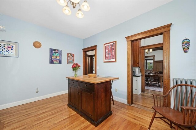 office with a chandelier, light wood-style floors, and baseboards