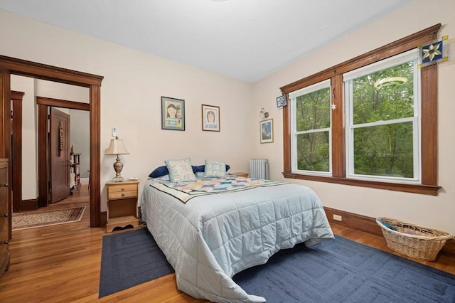 bedroom with light wood finished floors and radiator heating unit