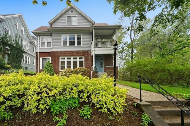 view of front of property featuring a balcony and brick siding