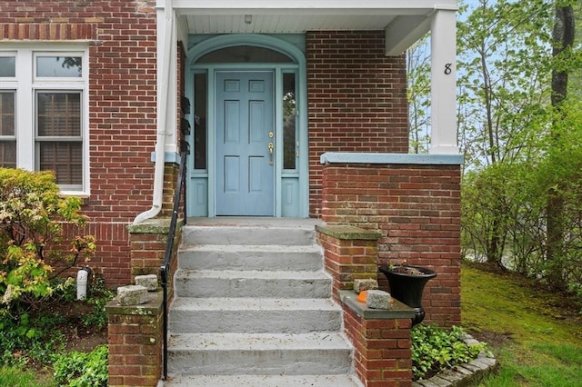 doorway to property with brick siding