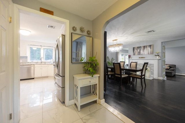 109 Circle Dr, Wrentham, MA 02093 - hall featuring arched walkways, a chandelier, and light marble finish flooring