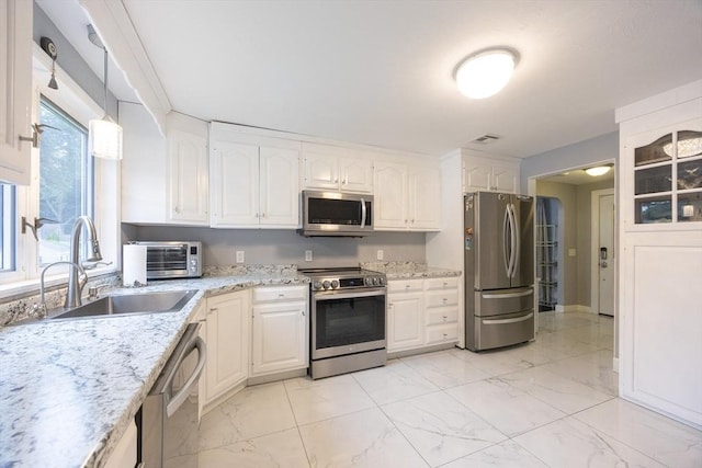 109 Circle Dr, Wrentham, MA 02093 - kitchen featuring appliances with stainless steel finishes, white cabinets, light marble finish floors, and light stone counters