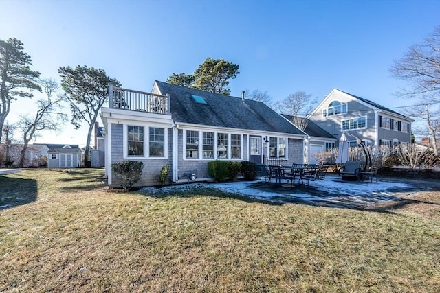 rear view of property with a balcony, a shed, a lawn, and a patio