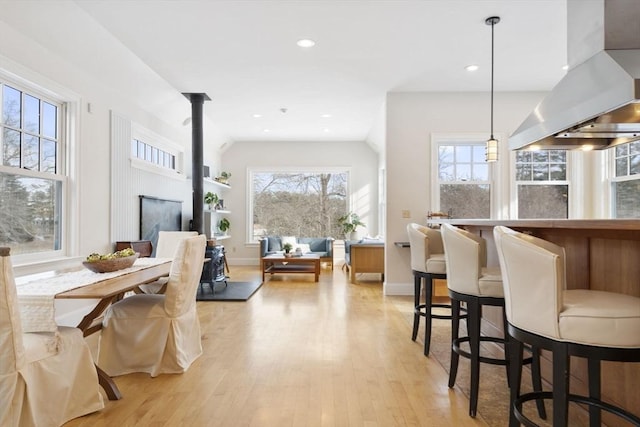 dining area with baseboards, vaulted ceiling, recessed lighting, and light wood-style flooring
