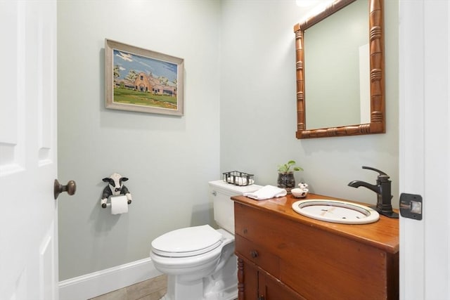 bathroom with vanity, baseboards, toilet, and tile patterned flooring