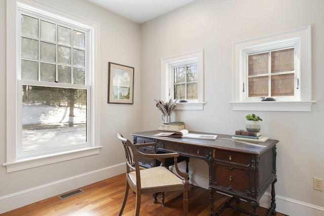 home office with visible vents, baseboards, and wood finished floors