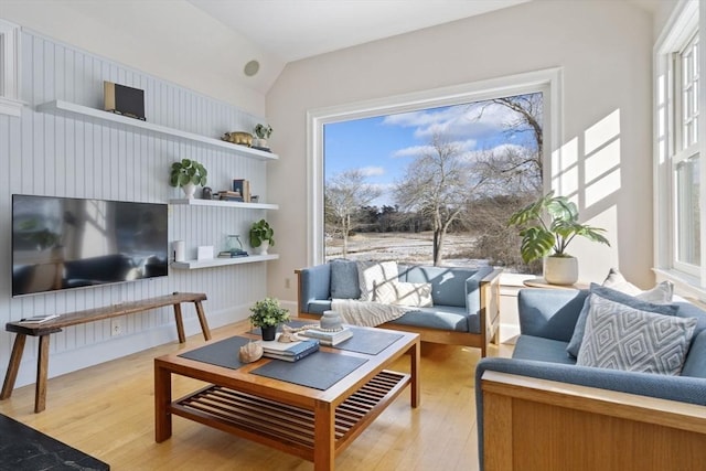 living room with light wood-style floors and vaulted ceiling