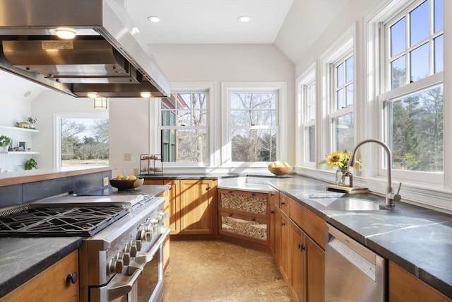 kitchen with brown cabinets, a sink, stainless steel appliances, lofted ceiling, and range hood