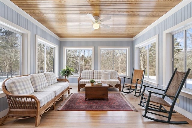 sunroom featuring ornamental molding, wood finished floors, a healthy amount of sunlight, and wallpapered walls