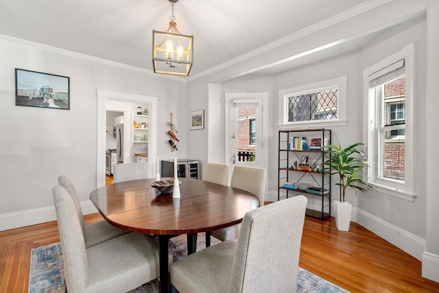 17 Park Vale Unit 2, Brookline, MA 02446 - dining area featuring a chandelier, baseboards, light wood-style flooring, plenty of natural light, and ornamental molding