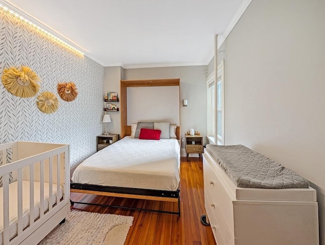 17 Park Vale Unit 2, Brookline, MA 02446 - bedroom featuring an accent wall, wallpapered walls, wood-type flooring, and ornamental molding