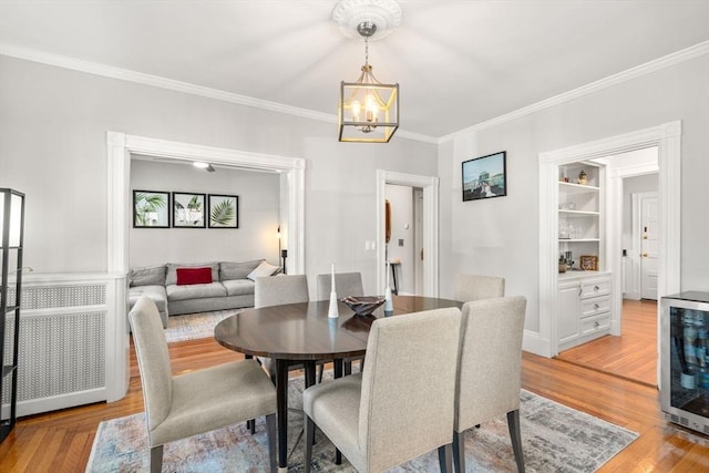 17 Park Vale Unit 2, Brookline, MA 02446 - dining area featuring a chandelier, crown molding, beverage cooler, and light wood finished floors