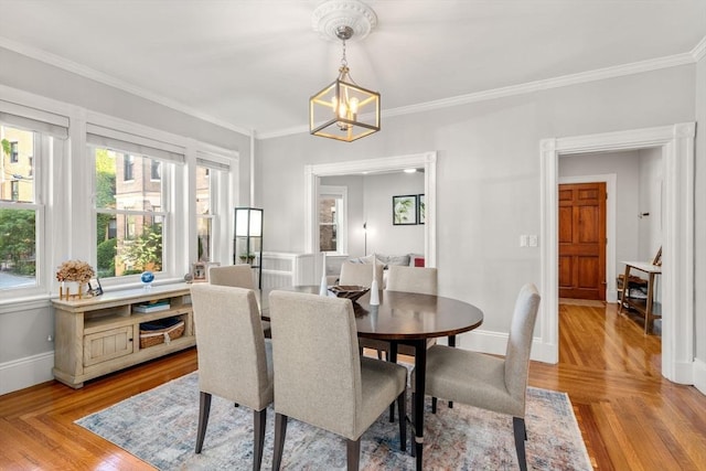 17 Park Vale Unit 2, Brookline, MA 02446 - dining space featuring a chandelier, crown molding, plenty of natural light, light wood finished floors, and baseboards