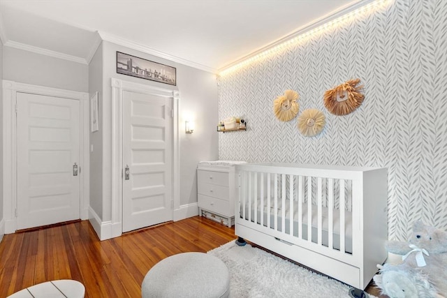 17 Park Vale Unit 2, Brookline, MA 02446 - bedroom with wallpapered walls, ornamental molding, an accent wall, hardwood / wood-style floors, and baseboards